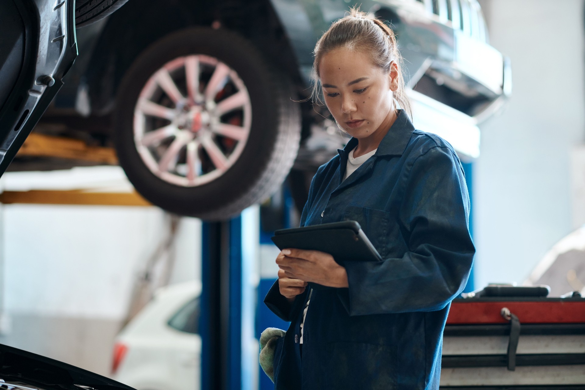 Shot of a female mechanic holding a digital tablet while working in an auto repair shop