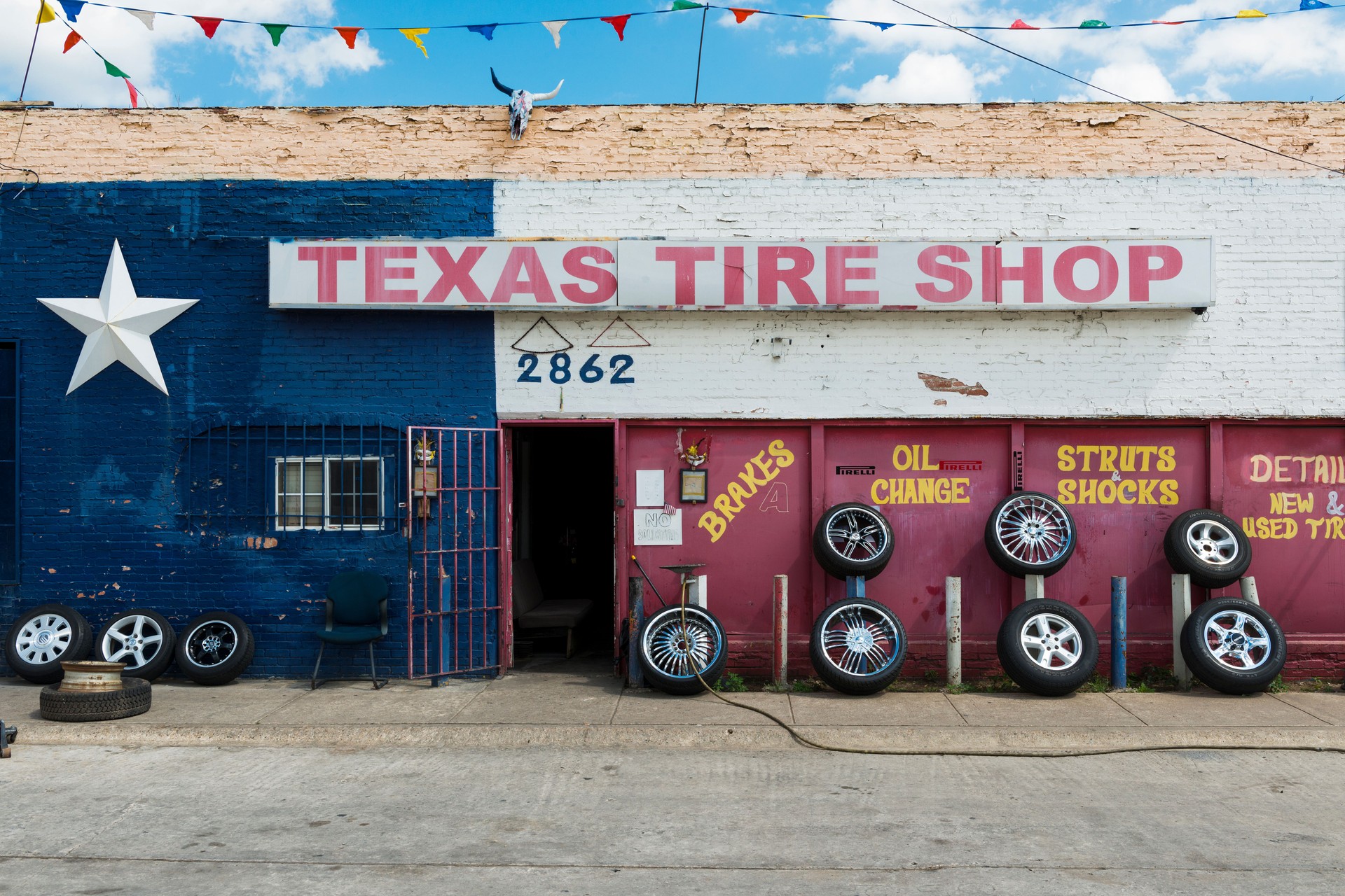 The exterior of a tire shop with the Texas Flag painted in the facade, in the city of Forth Worth, Texas